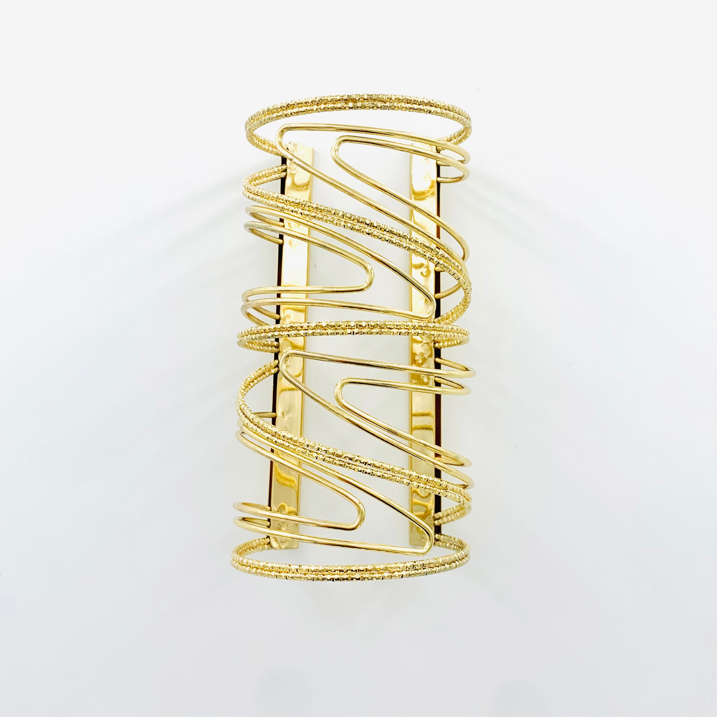 Wide cuff with wavy design in Gold