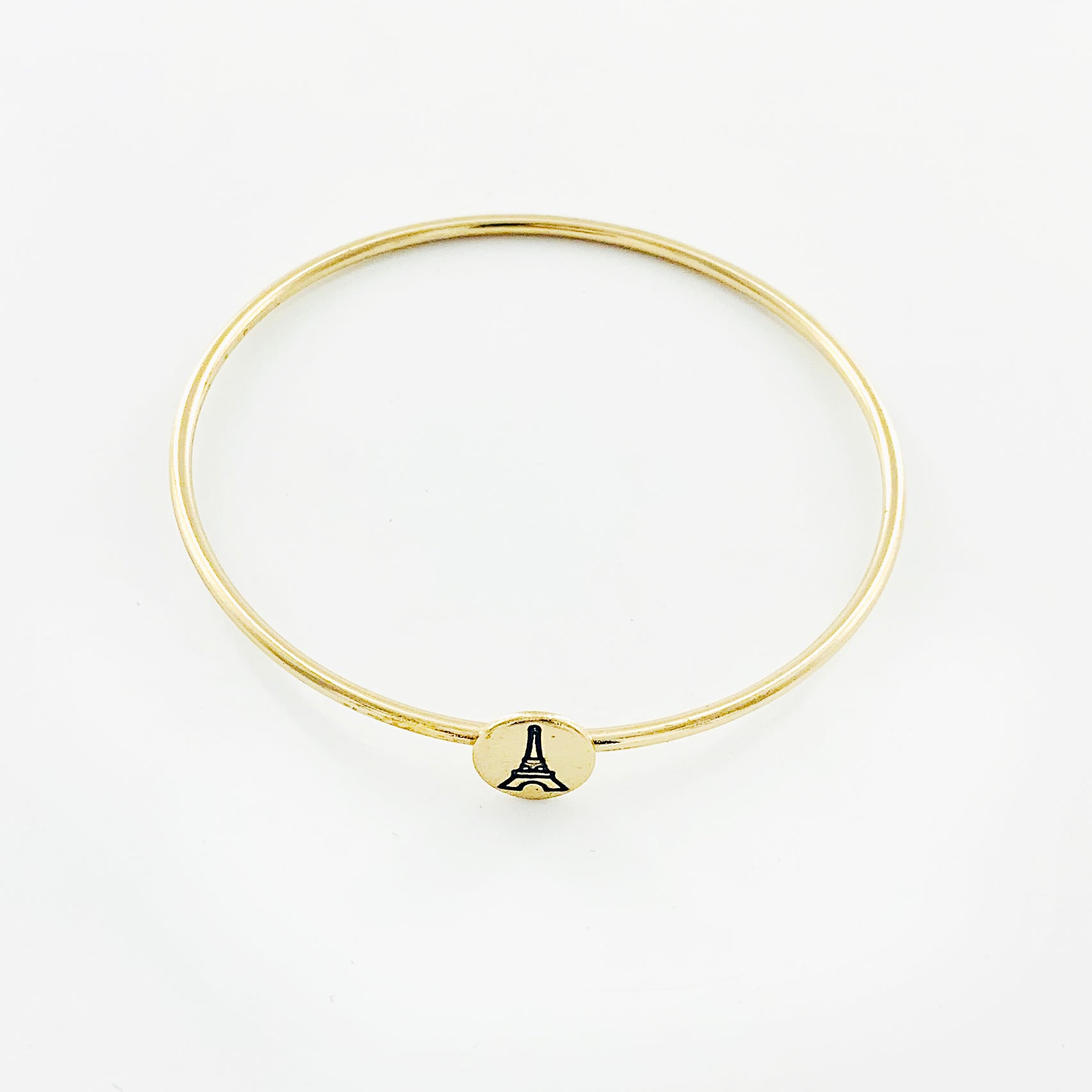 Thin gold bangle with engraved Eiffel Tower disc