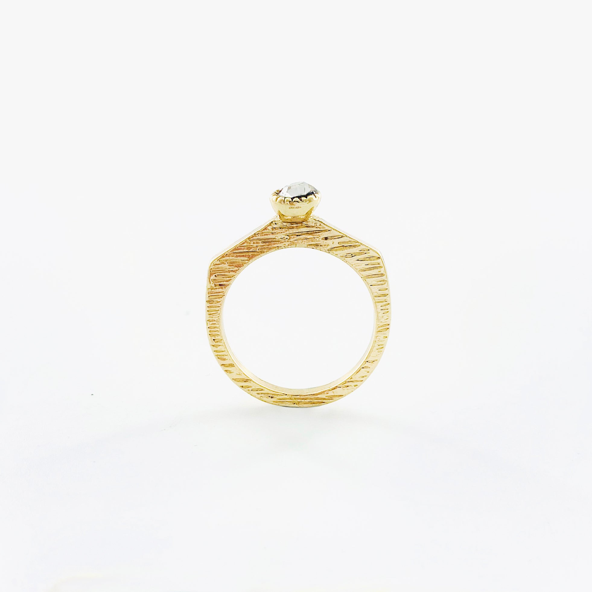 Textured gold ring with small white stone